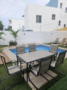 una mesa de picnic y sillas junto a una piscina en Privada Huayacan, en Cancún