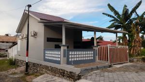 a small house with a porch and a fence at JH homestay 