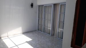 a room with white walls and glass doors at JH homestay  +3 photos