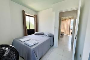 a bedroom with a bed with blue sheets and a window at Duplex 111 Beira-mar Pajuçara in Maceió