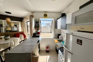 a kitchen with a counter and a large window at Duplex 111 Beira-mar Pajuçara in Maceió