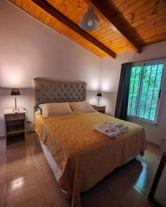 a bedroom with a bed and a large window at La caballeriza departamentos in Alta Gracia