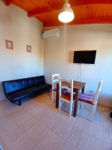 a living room with a couch and a table and chairs at La caballeriza departamentos in Alta Gracia