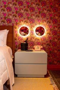 Un dormitorio con una cama y dos espejos en la pared. en Hotel Hilo - Room 204, en Louisville