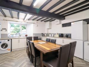 a kitchen with a wooden table and chairs at Plas Yn Bonwm in Carrog