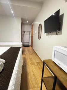 a room with a bed and a tv on a wall at Suítes Viver Arraial do Cabo in Arraial do Cabo +91 photos