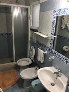 a bathroom with two toilets and a sink and a mirror at Appartamenti da Giorgio e Lina in Ischia
