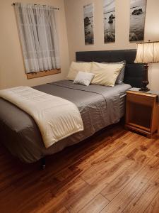 a bed in a bedroom with a wooden floor at Sutaz Ocean Side Home in Port Dufferin