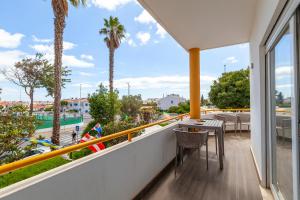 een balkon met een tafel en stoelen en palmbomen bij Southern place Guesthouse in Lagos