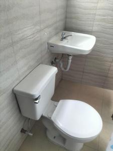 a bathroom with a toilet and a sink at Home in Tulcán