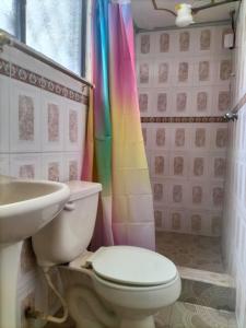 a bathroom with a toilet and a sink at Home in Tulcán