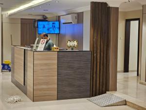 a woman standing at a reception desk in a lobby at واجهةالشرقيةللضيافةالخاصة in Al Khobar