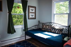 a bedroom with a bed and two windows at Cozy Forest Escape with Porch and AC in Lost City