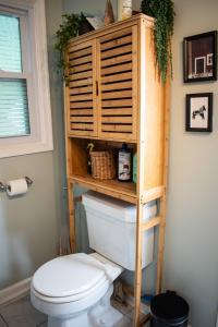 a toilet in a bathroom with a wooden shelf above it at Cozy Forest Escape with Porch and AC in Lost City +31 photos