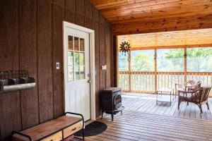 a screened in porch with a stove on a deck at Cozy Forest Escape with Porch and AC in Lost City