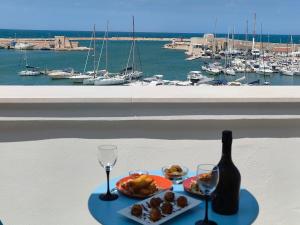 a table with a bottle of wine and a plate of food at CconfortHotels Sea Dream Palace 1 in Trani +71 photos
