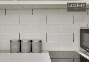 New! Stunning Studio City Centre Nr High St by Luxiety Stays في ساوثيند أون سي: أربعة صناديق قمامة اصطفت مقابل جدار من البلاط الأبيض +10 صور