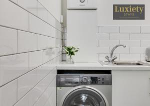 New! Stunning Studio City Centre Nr High St by Luxiety Stays في ساوثيند أون سي: وجود غسالة ملابس في مطبخ بجانب مغسلة