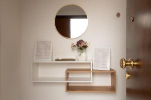 a room with a mirror and a shelf with flowers at Terrazza Mira - Guest House in Todi