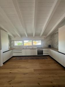 a large kitchen with white cabinets and a wooden floor at Apartment with Jacuzzi near Como Milano FREE PARKING in Mozzate