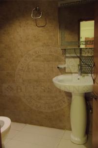 un baño con lavabo y un cartel en la pared en Bless-Inn & Restaurant, en Islamabad