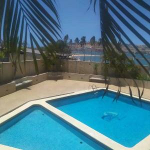 a large blue swimming pool with a view of the beach at Bello Apartamento en Playa Lido, lechería in El Morro de Barcelona