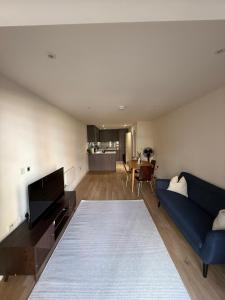 a living room with a blue couch and a table at New London 2-Bedroom 2-Bath Apartment- Contractors and Long Stays Dis-Count in Colindale