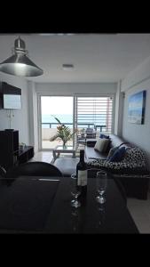 a living room with a couch and a table with wine glasses at Bello Apartamento en Playa Lido, lechería in El Morro de Barcelona