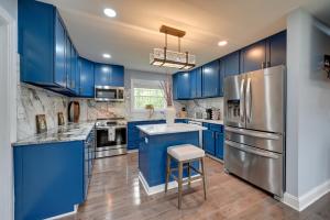 a blue kitchen with stainless steel appliances and blue cabinets at 5 Mi to Lake Thom-A-Lex Pet-Friendly Retreat in Thomasville