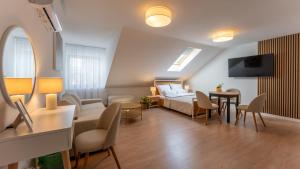 a living room with a bed and a dining room at Apartamenty Zamojska in Zwierzyniec