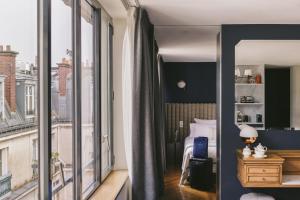 a bedroom with a bed and a large window at Hotel Bachaumont in Paris