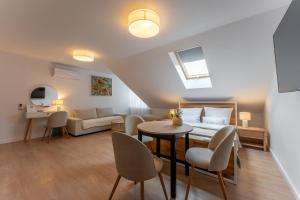 a living room with a bed and a table and chairs at Apartamenty Zamojska in Zwierzyniec