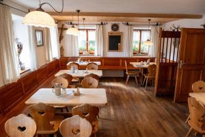 a restaurant with wooden tables and chairs and windows at Gasthaus Hansch in Egling