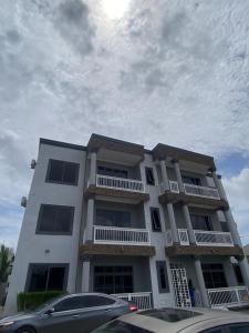 a white building with cars parked in front of it at Beeba's Suite in Kwabenya +17 photos