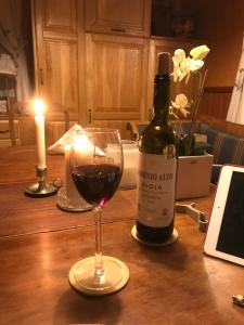 a glass of red wine next to a bottle of wine at Lakeside Guesthouse, Lillstugan in Ramvik