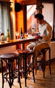 a man sitting on a stool at a bar at Hotel Chalet du Crey in Valmorel
