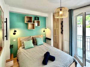 a bedroom with a large bed with a blue wall at T3 tout neuf 6 personnes proche centre ville in Luchon