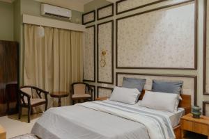 a bedroom with a large bed and a table and chairs at Omnia By Alhanney in Guwahati
