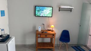 a desk with a lamp and a blue chair in a room at Coliving Bem Estar in Bauru