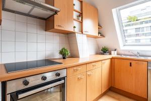 une cuisine avec des armoires en bois, un évier et une fenêtre dans l'établissement Trocadero Eiffel cozy apartment, à Paris 5 autres photos