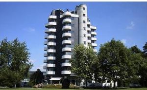 a large apartment building in a park with trees at Ringhotel Parkhotel Witten in Witten