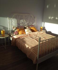 a bedroom with a bed with a metal headboard and two lamps at ART HOUSE Kosmaj 2 in Sopot