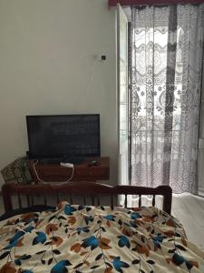 a bedroom with a bed and a tv and a window at Au cœur de Bejaia in Bejaïa