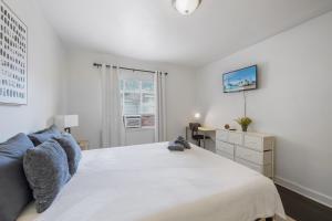 ein weißes Schlafzimmer mit einem großen Bett und einem Schreibtisch in der Unterkunft 20 Minute Walk to Tiger Stadium - Near Downtown in Baton Rouge