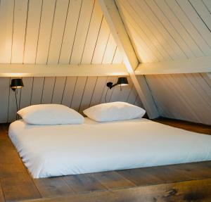 two white pillows sitting on a bed in a attic at Villa la Vida in Tilburg