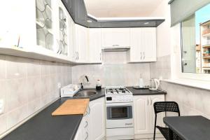 a kitchen with white cabinets and a sink at Amber room in Sopot +1 photo