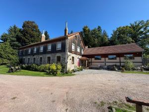 una grande casa in mattoni con un edificio di Domaine de la prairie des prés a Vagney