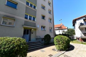 an apartment building with a blue door and some bushes at Amber room in Sopot