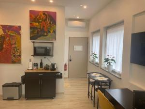 a living room with a kitchen and a table at SUITE Quattro Ducati in Kirchheim unter Teck +7 photos