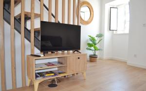 TV en un soporte de madera en la sala de estar en Casa Miradouro das Beatas, en Elvas 3 fotos más
